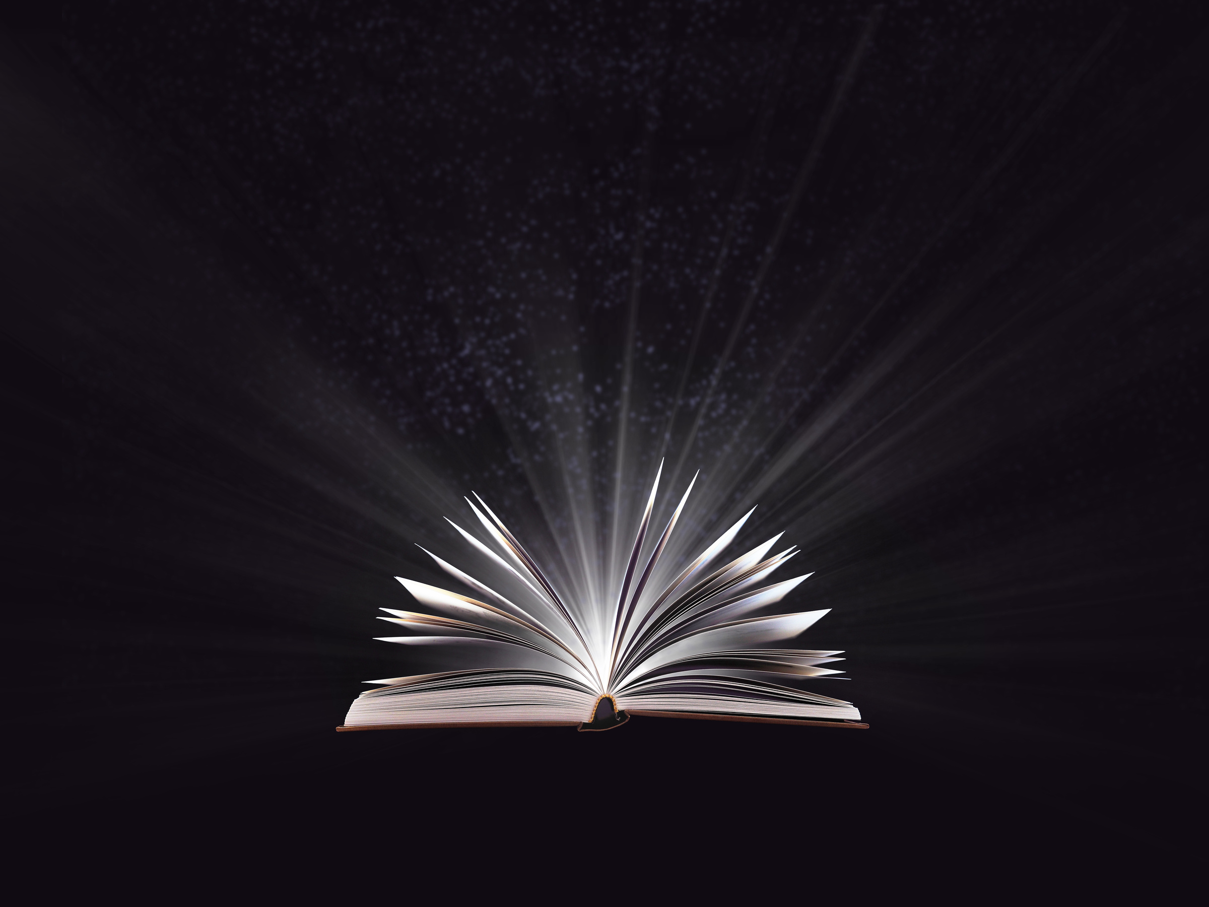 An open magic book, bewitched book glows in the darkness, magic light. Education. Dreamy image of a fairytale